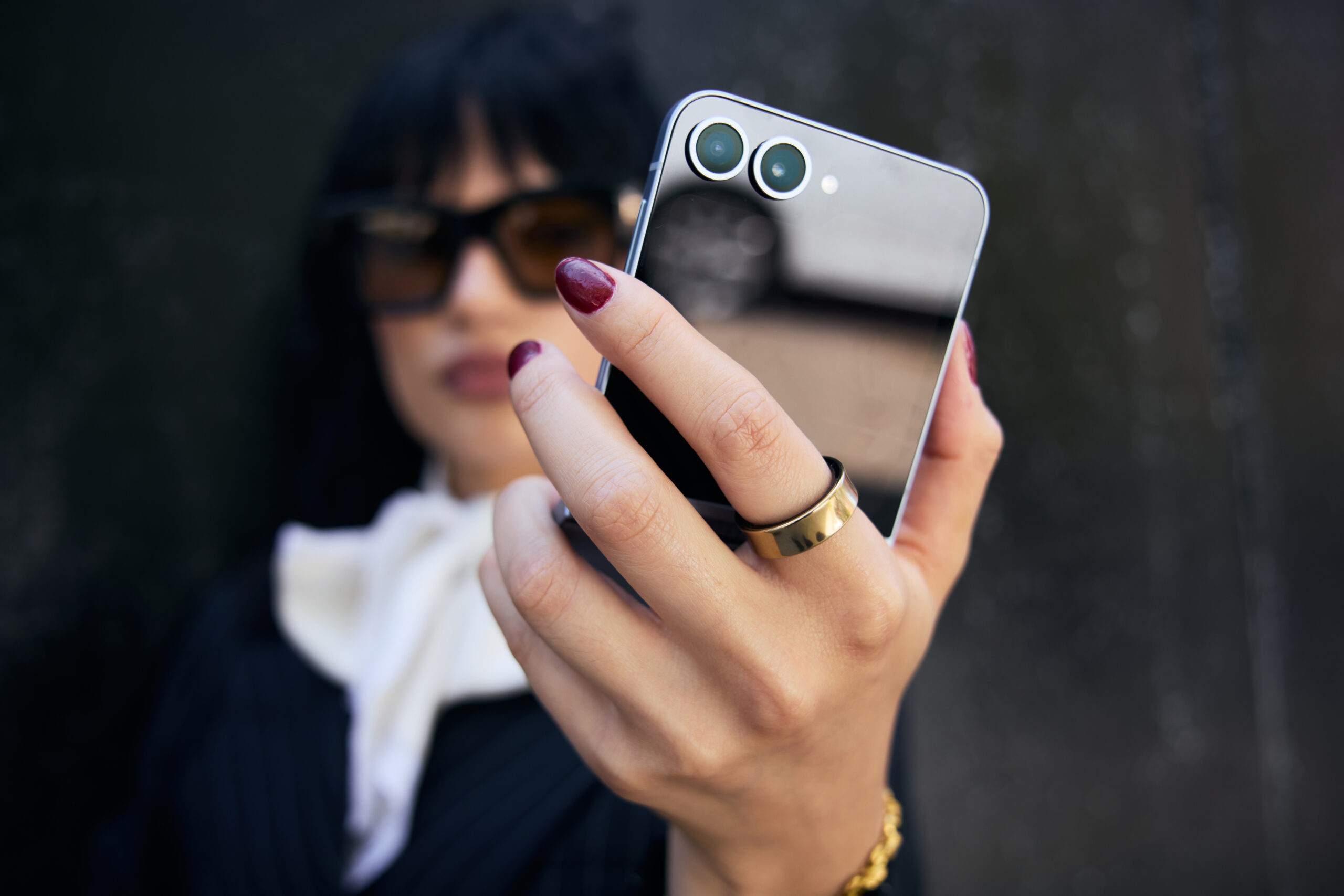 Femme tenant un téléphone et portant une Samsung Galaxy Ring