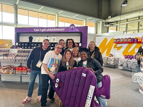 Group of tms-ers running the fandom store posing with a Grimace toy